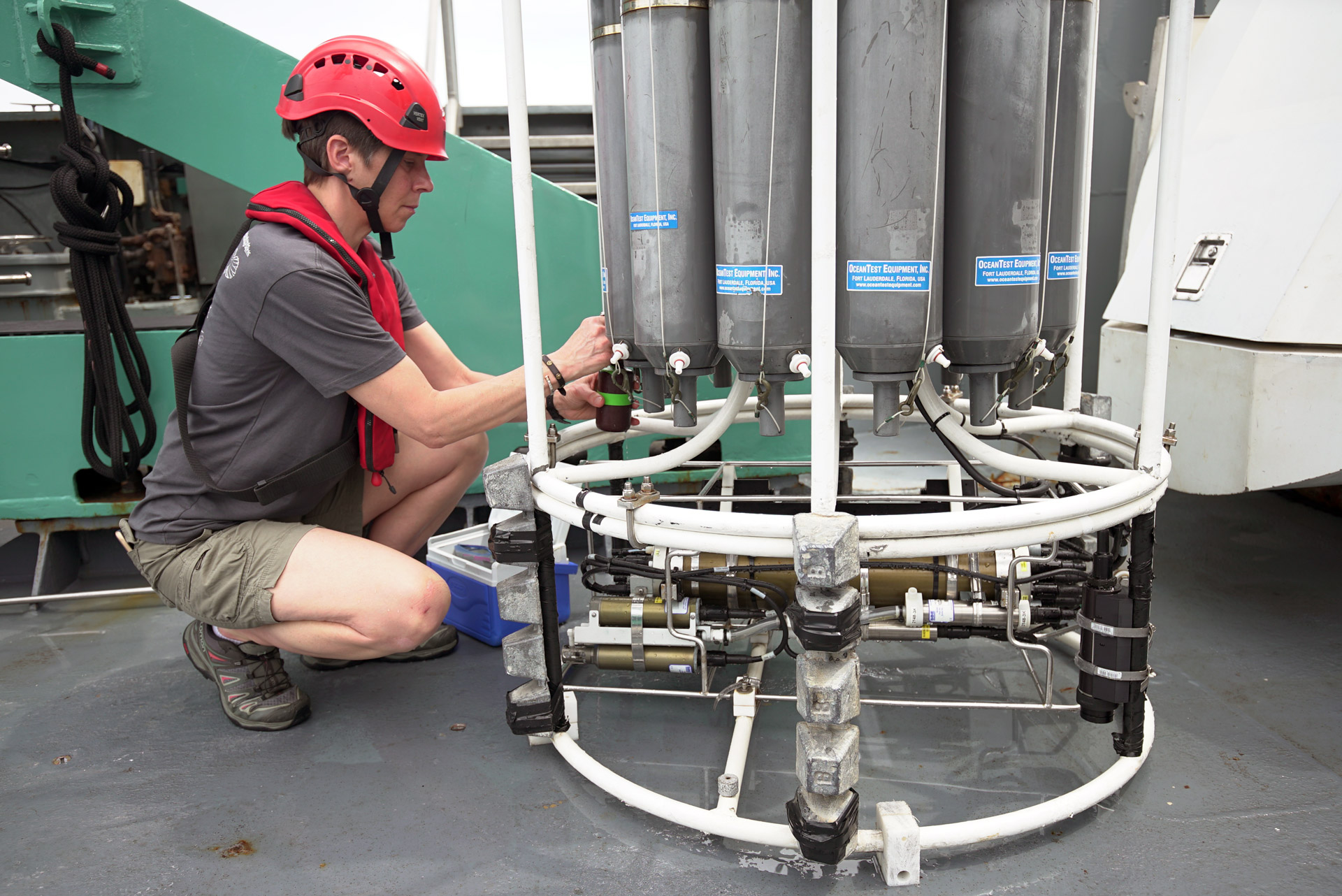scientist takes water samples from a CTD