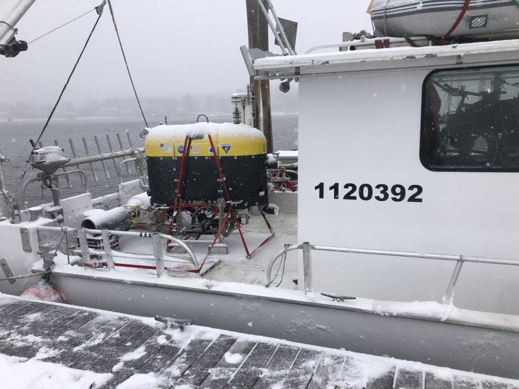 <em>Mesobot</em>, the OTZ team's autonomous underwater vehicle, rests on the deck of the 35-foot <em>R/V Catapult</em> in Woods Hole. It will soon leave the icy northeast for the white and pink sands of Bermuda.