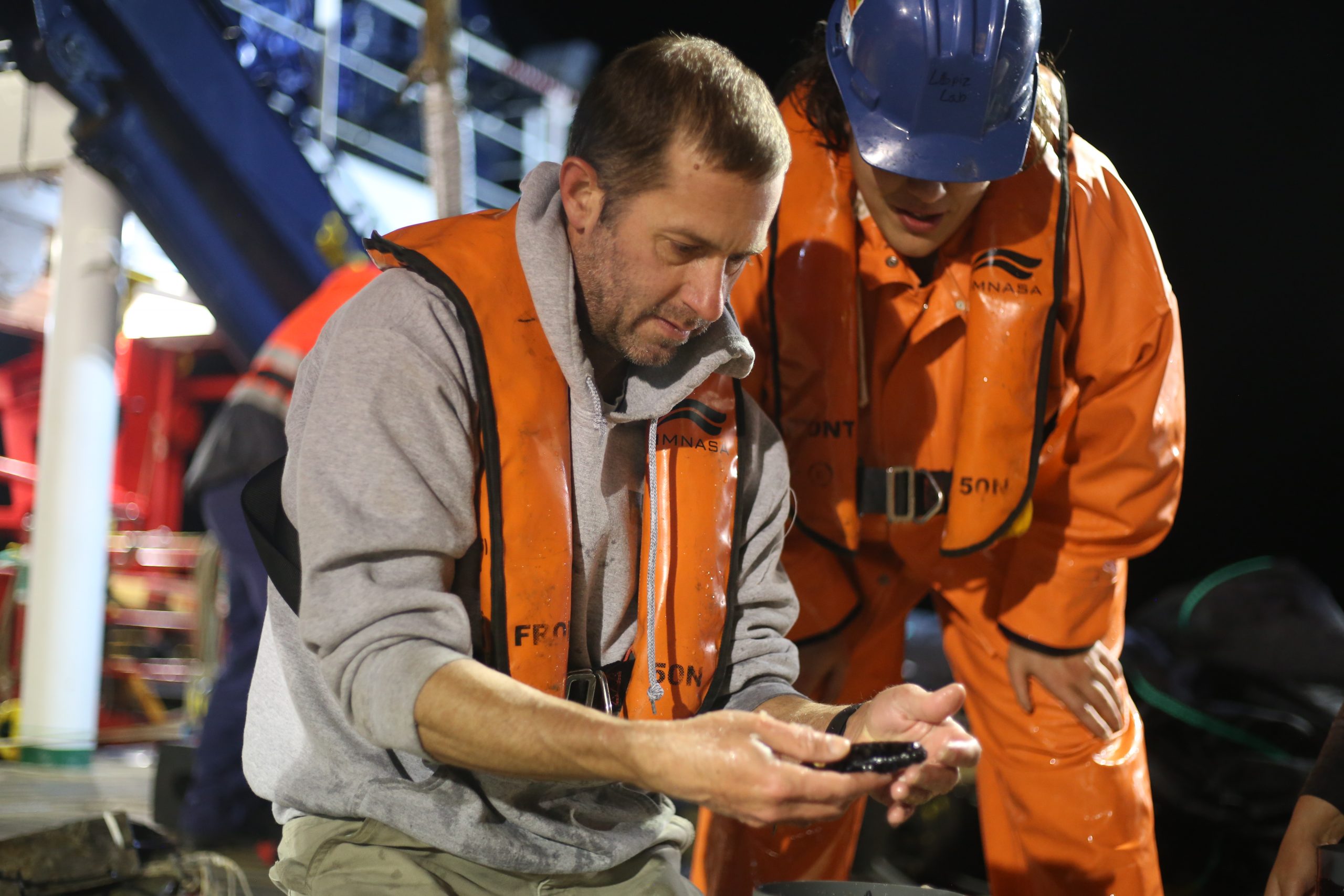 OTZ researcher Joel Llopiz (Left) examines a fish from the twilight zone during a net tow in 2021.