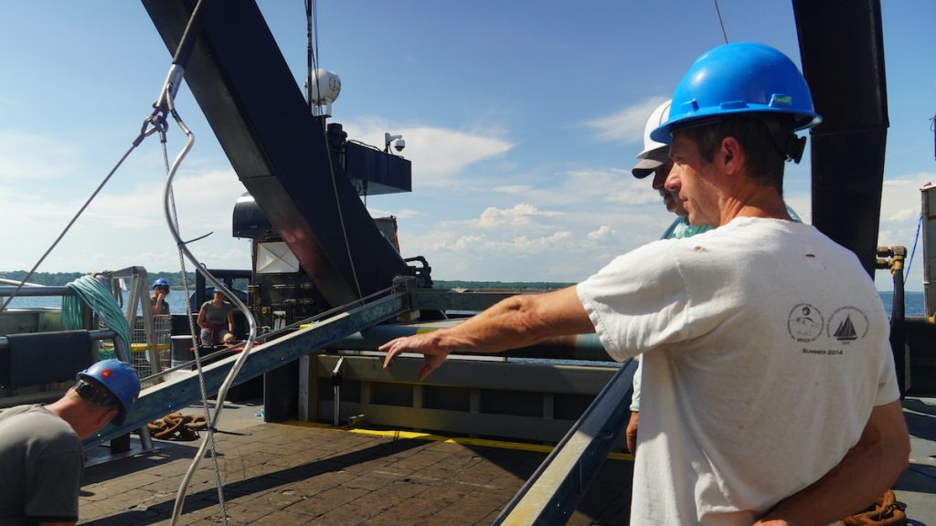 Joel Llopiz directs engineers as they maneuver the MOCNESS, or the Multiple Opening and Closing Net with an Environmental Sensing System. 
(Photo by Andrea Vale © Woods Hole Oceanographic Institution)