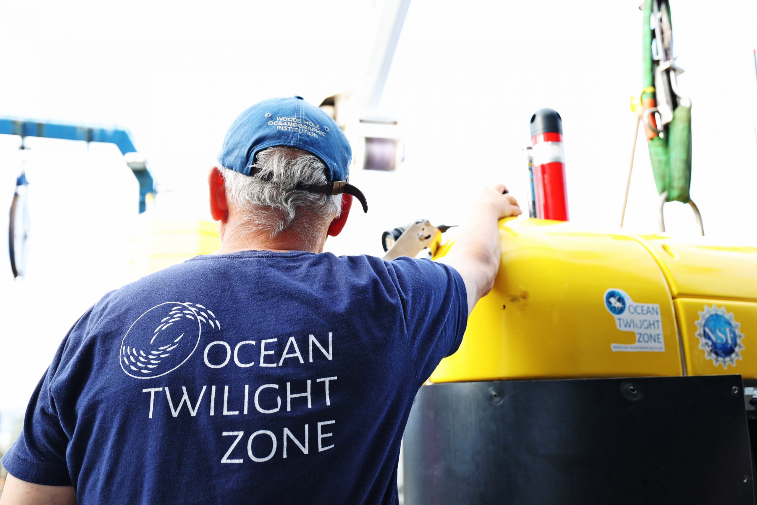 Dr. Dana Yoerger, Senior Scientist at the Woods Hole Oceanographic Institution, leans against the side of <i>Mesobot</i>. Yoerger led the team that designed and built the robotic vehicle. 