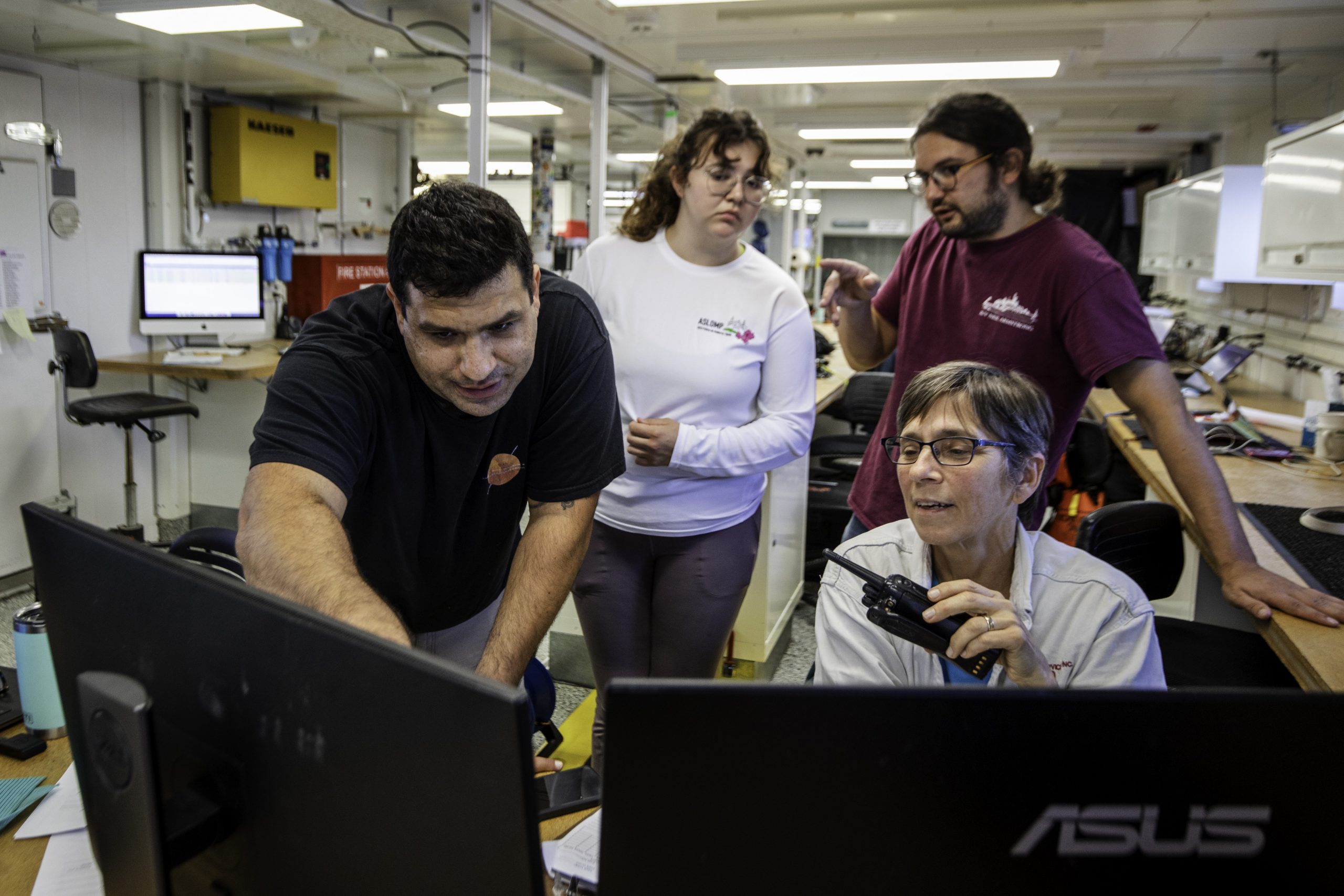 WHOI postdoc Ben Grassian (left) and marine biologist Heidi Sosik examine images from the twilight zone as they arrive onboard the R/V <i>Armstrong</i>.