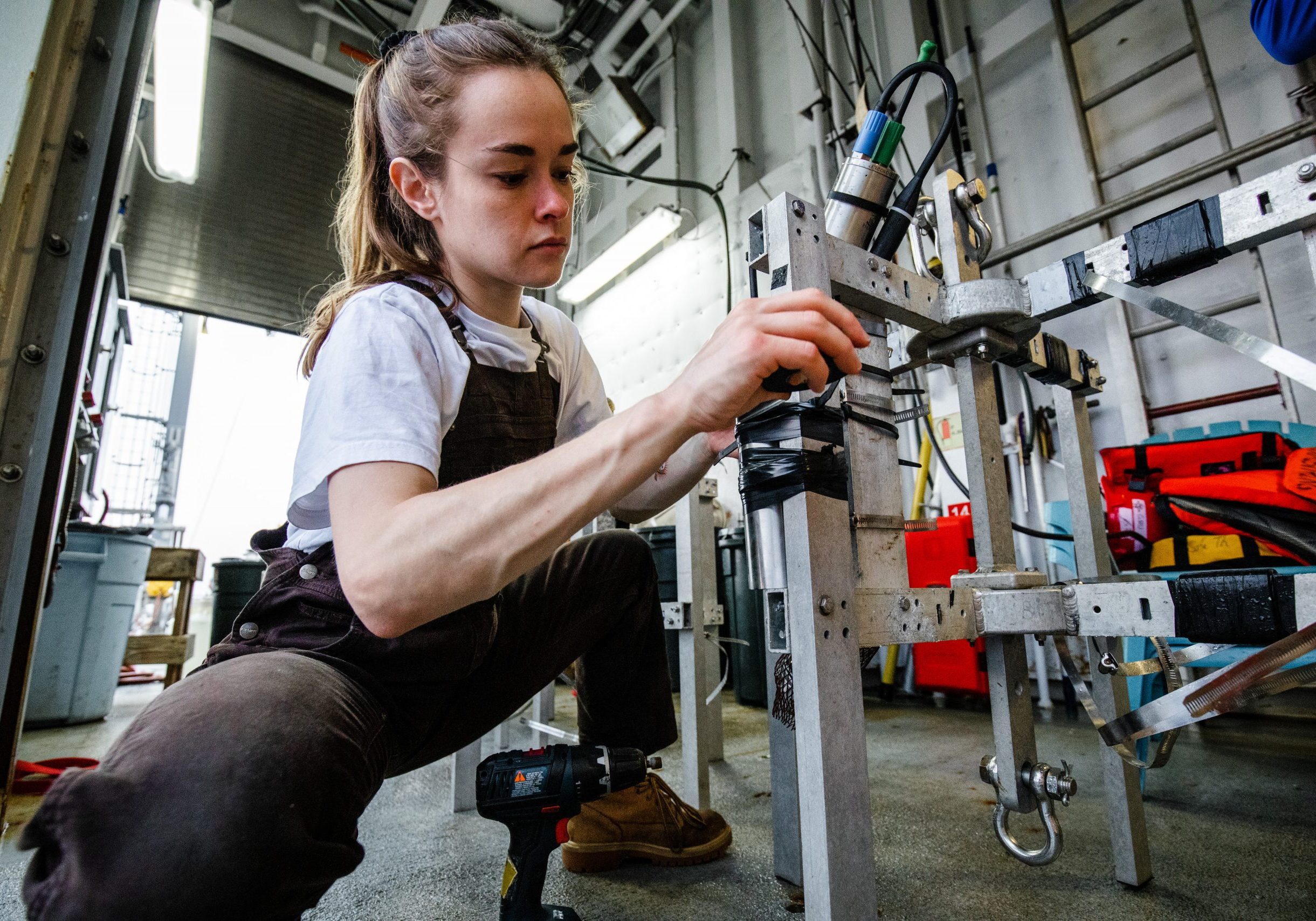 MIT-WHOI Joint Program Student Samantha Clevenger  attaches bathymetric and temperature sensors to several small surface-tethered traps that will collect organic carbon floating down in the ocean twilight zone.