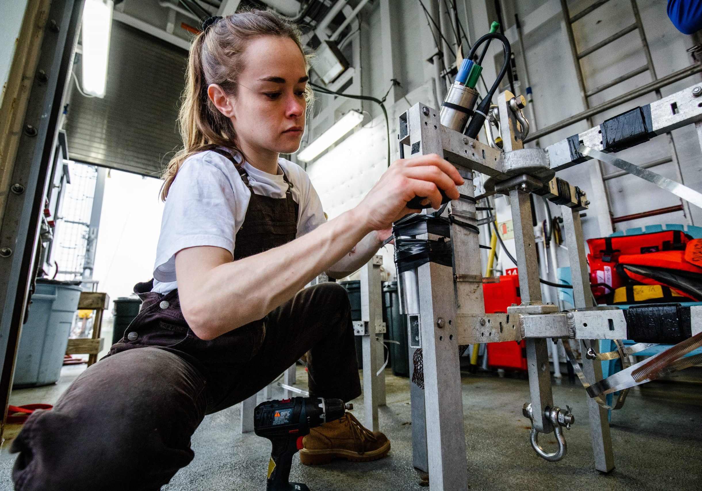 MIT-WHOI Joint Program Student Samantha Clevenger  attaches bathymetric and temperature sensors to several small surface-tethered traps that will collect organic carbon floating down in the ocean twilight zone. Photo by Danny Hentz, © WHOI