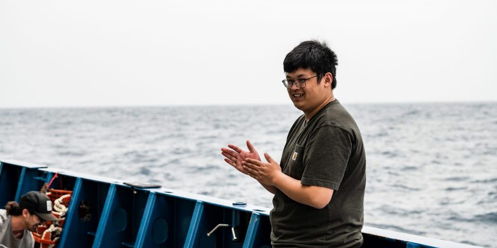 MIT-WHOI Joint Program student Zhaozhong Zhuang (Lavery Lab) shares a laugh with the science crew aboard the R/V <i>Armstrong</i>in between mooring operations.