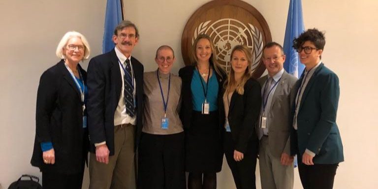 WHOI researchers in front of the seal of the United Nations